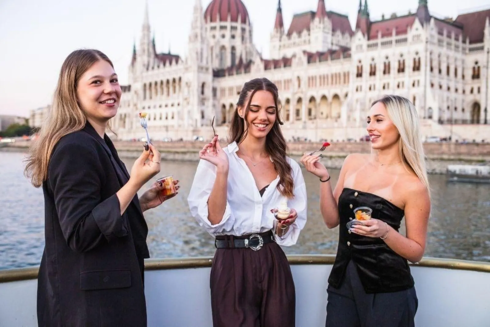 Three friends on deck with the Parliament behind them