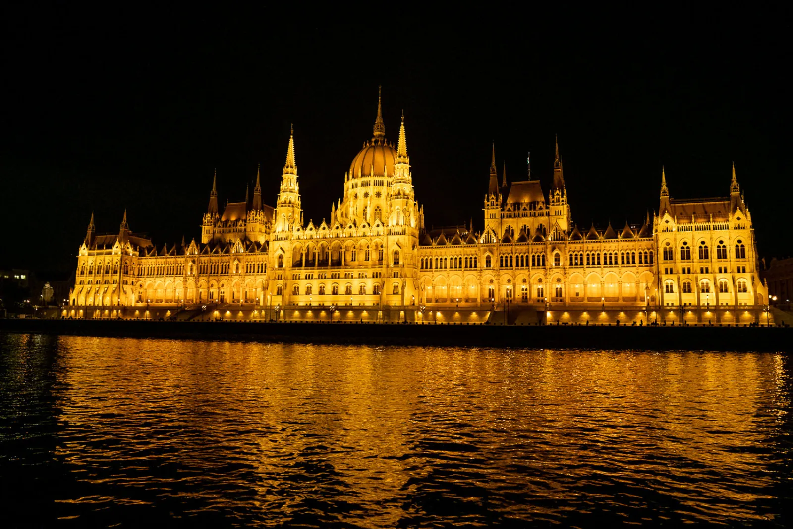 The Hungarian Parliament floodlit across the Danube at night