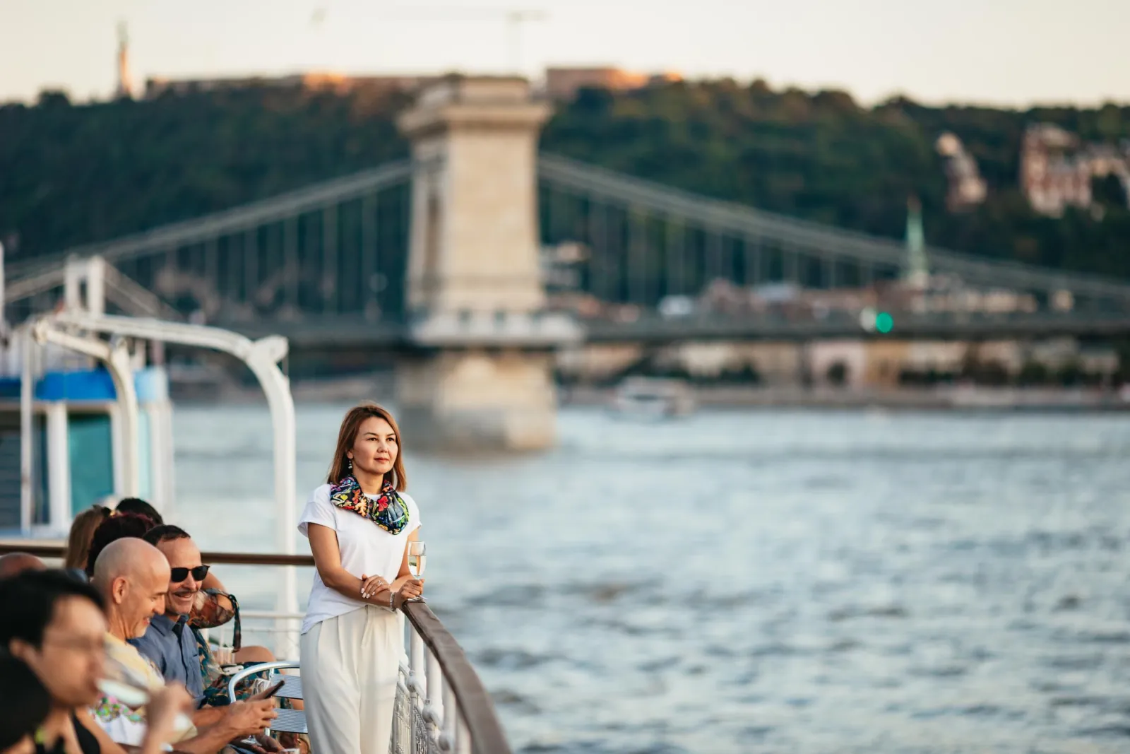 A guest at the rail with the Chain Bridge behind her