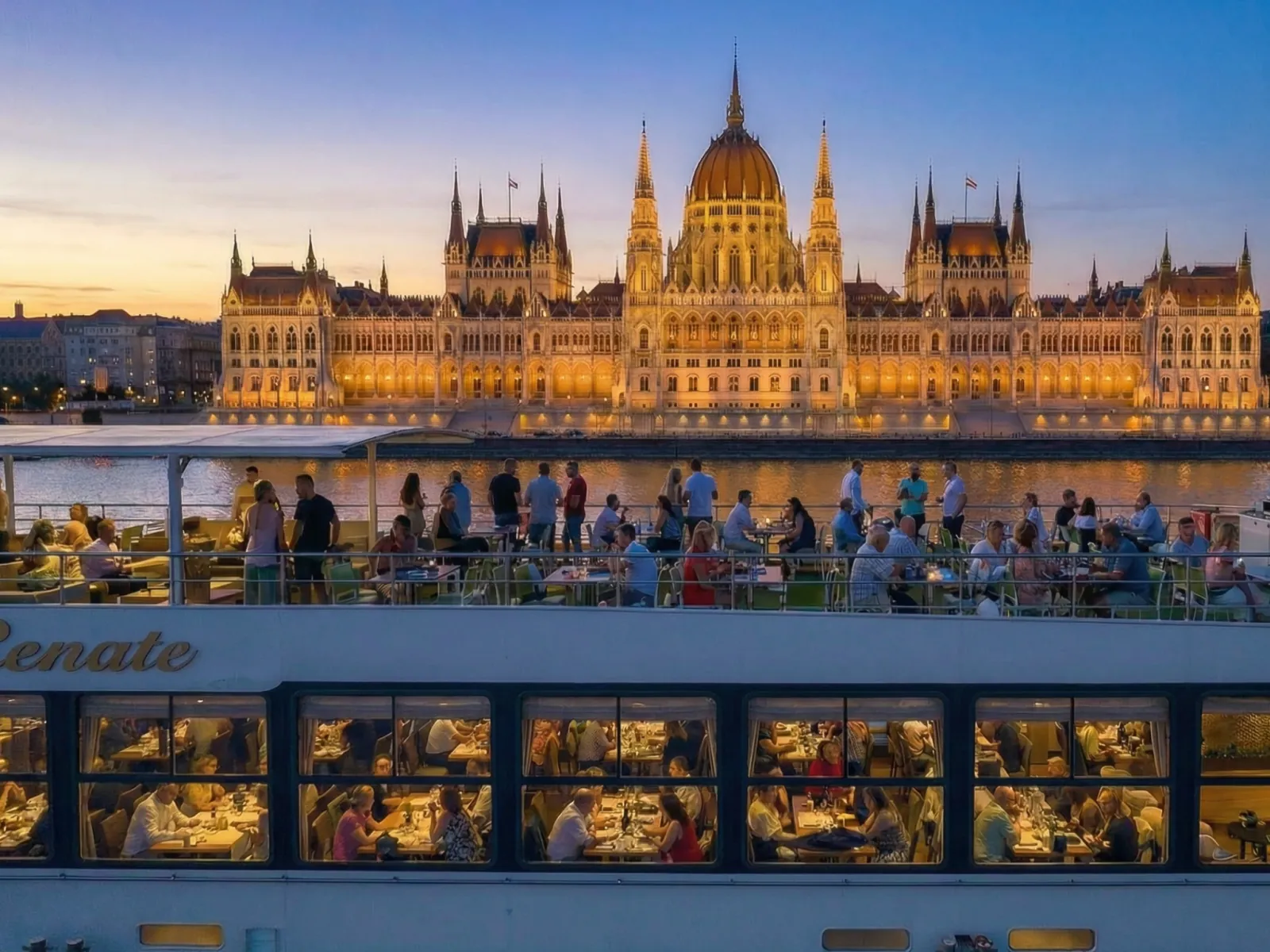 Guests on deck with the Parliament behind them at dusk