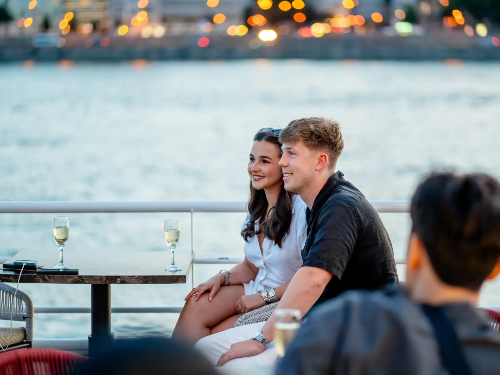 A couple seated on the open deck at sunset