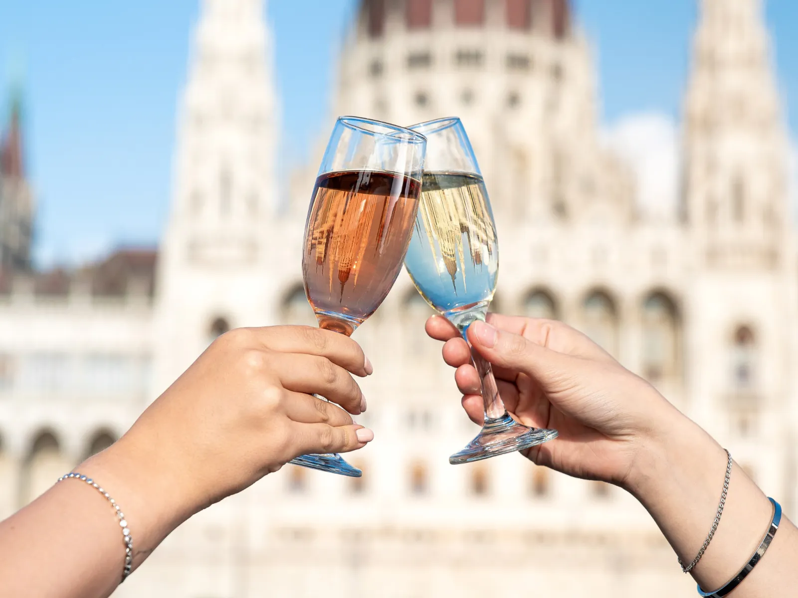 Two glasses of rosé raised with the Parliament behind
