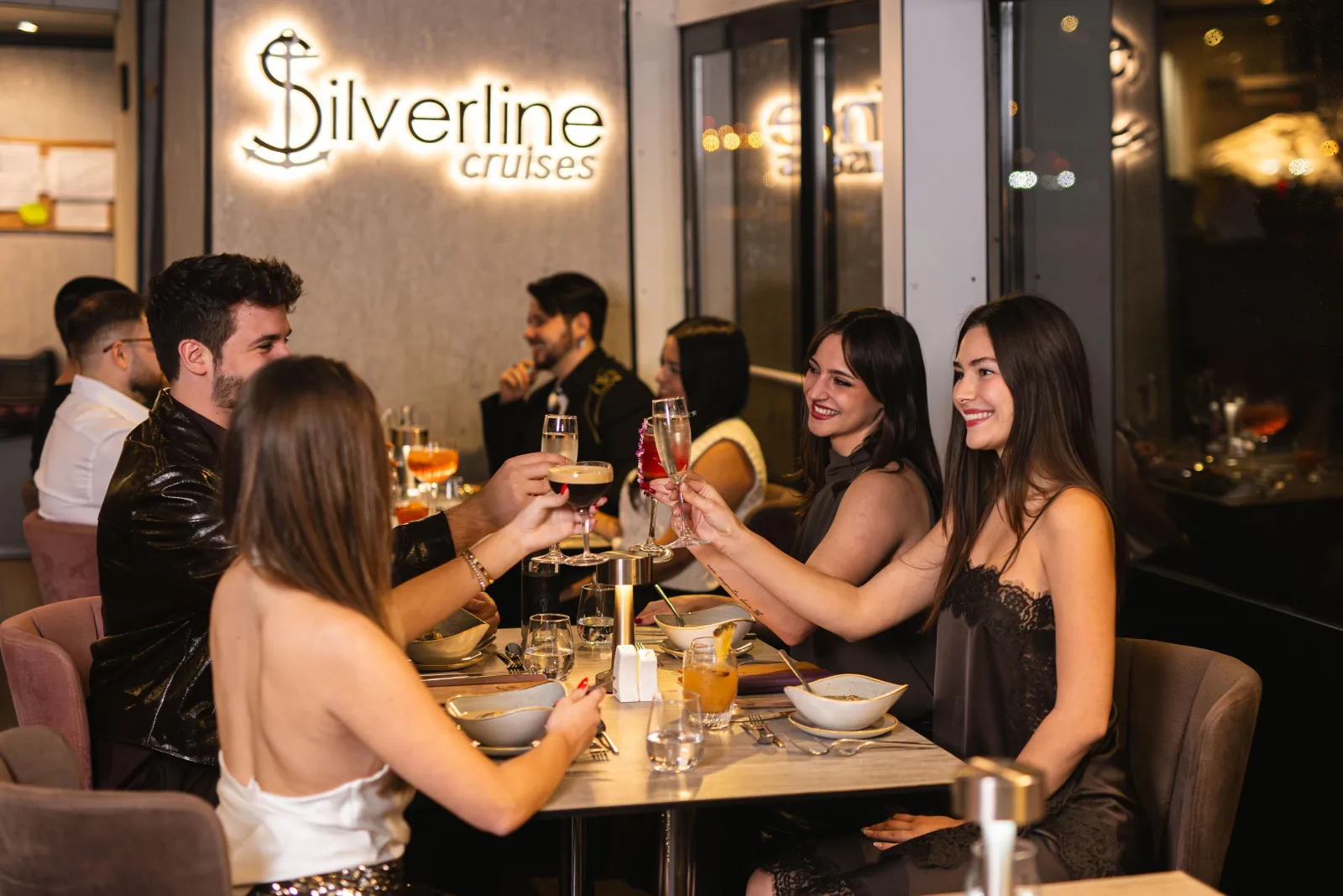 A group of friends at a table beside the Silverline sign