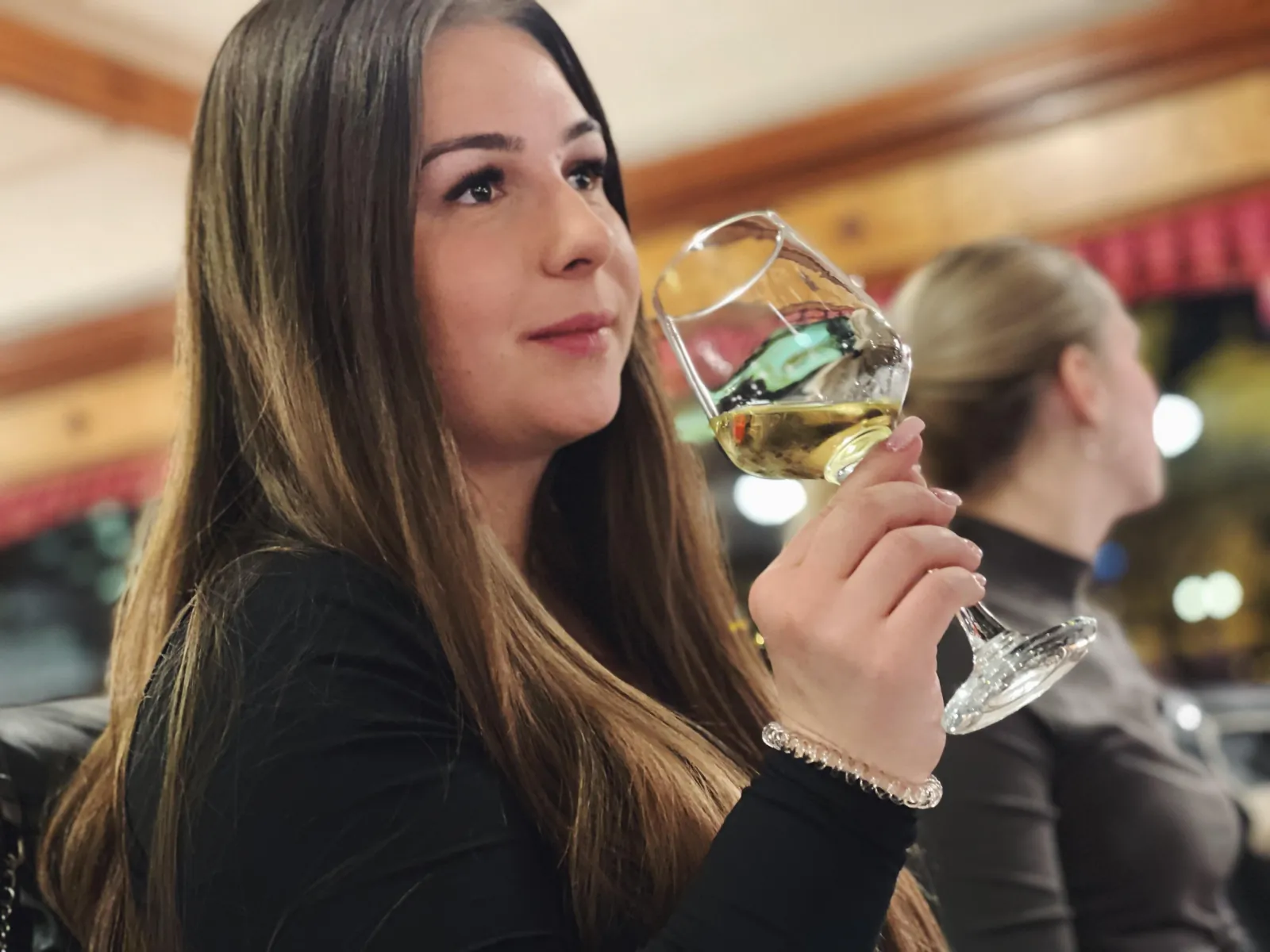 A guest tasting white wine at her table