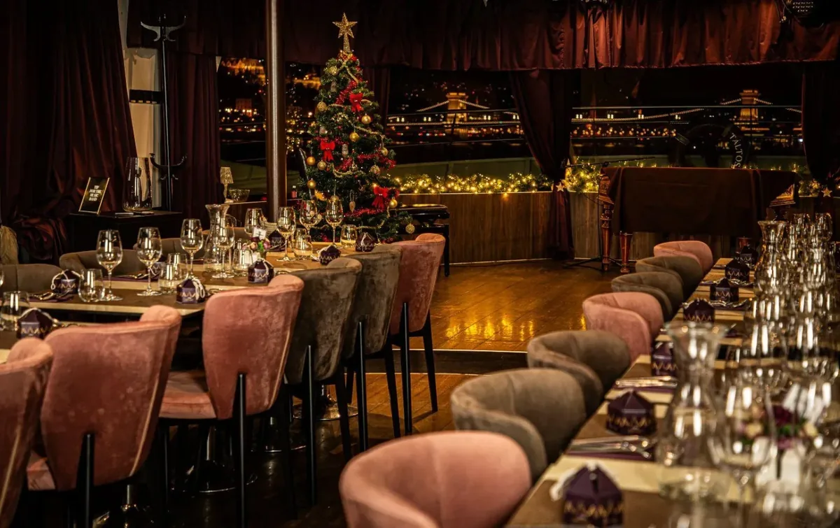 A Danube cruise dining room set for Christmas with a decorated tree and candles
